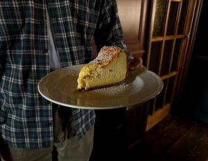 佛罗伦萨赫米缇吉酒店的把一块蛋糕放在盘子里的人