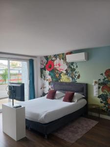 维拉尔雷东布Touraco的一间卧室设有一张带花卉墙壁的大床