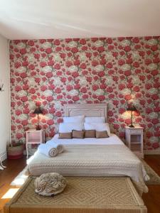 LamarqueLa Maison Reverdi的一间卧室设有一张带花卉墙壁的大床