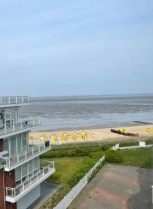 库克斯港Traumhafte Ferienwohnung - direkter Meerblick - 50m zum Strand in Cuxhaven Duhnen in 1A Lage im Haus Seehütte的享有海滩、建筑和大海的景色