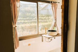 萨帕Plum Eco House的浴室里的窗户,架子上有一个碗