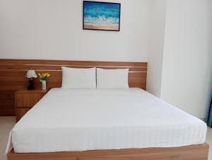 芽庄Thanh Hien villa的一间卧室配有一张带白色床单的大床