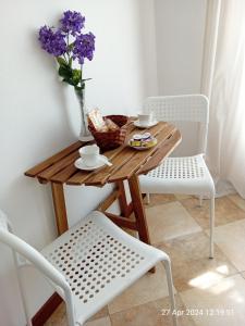 斯培西亚IL GIARDINO的一张带花瓶的木桌和两把椅子