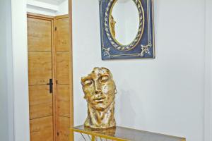 佩皮尼昂Le Penthouse des Halles的镜子旁桌子上的金头雕像