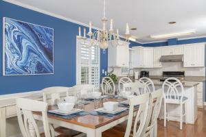 翡翠岛Azure home的一间拥有蓝色墙壁和桌椅的用餐室