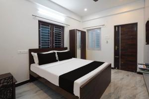 钦奈Hotel Stay inn Chennai Airport的一间卧室配有一张大床,铺有黑白床单。