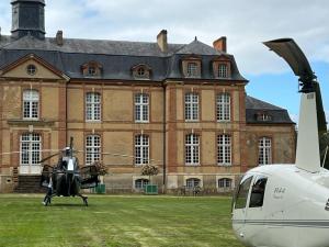 勒芒24H LE MANS Château de Lauresse chambres d'hôtes Luxe的停在大楼前的直升机