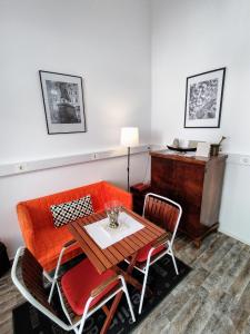 萨格勒布Olive Tree City Apartment的一间带橙色沙发和桌子的用餐室