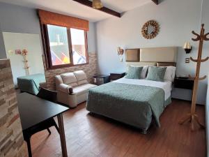 利马廷科斯酒店的一间卧室配有一张床、一张沙发和一把椅子