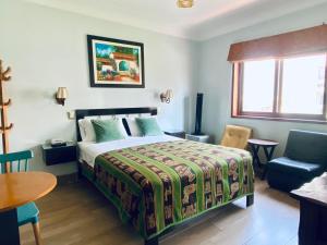 利马廷科斯酒店的卧室配有1张床、1张桌子和1把椅子