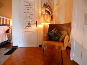 菲乌米奇诺Villa Gisi Guest House的一间带椅子和一盏灯的房间和一间卧室