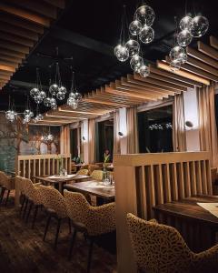梅斯佩尔布伦祖姆恩格尔酒店的餐厅设有木桌、椅子和吊灯。