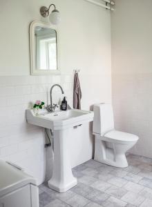 恩雪平Vallby Cottage的白色的浴室设有水槽和卫生间。