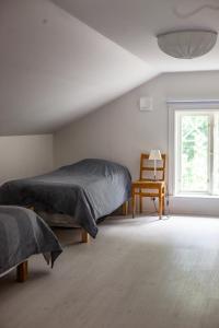 恩雪平Vallby Cottage的一间卧室设有两张床、一把椅子和一个窗户。
