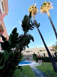 托雷德本纳贾尔邦Costa del Golf的棕榈树和游泳池度假村