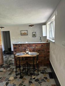 库伦瓦库夫Apartman Azra的厨房配有桌子和砖墙