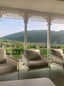 安布罗劳里Gonadze Vineyards Hotel的门廊上的两把椅子,享有山景