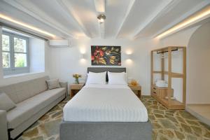 伊兹拉Douskos Citrus Apartments的一间卧室配有一张大床和一张沙发