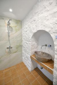 伊兹拉Douskos Citrus Apartments的一间带石质水槽和淋浴的浴室