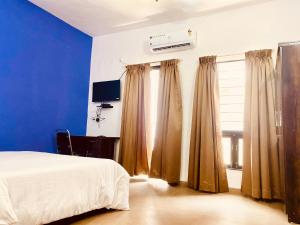 浦那Separate 2 AC Rooms Kalyani Nagar Near Pune Airport Osho Garden WTC的一间卧室配有床和带窗帘的窗户