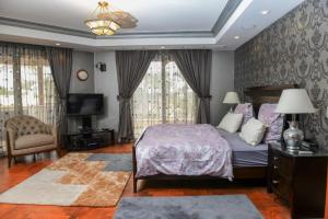 开罗Villa Al Mansouria的一间卧室配有床、电视和窗帘