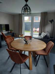 GrijpskerkeNIEUW Vakantiewoning Nimmerdor, Grijpskerke, dichtbij strand en stad的客厅配有木桌和椅子