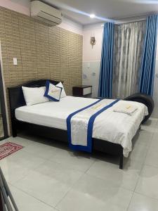 Dĩ Anhotel Hương Thiên Phú的一间卧室配有一张带蓝色窗帘的大床