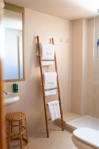 坎佩略Rooms by JovA的带镜子的浴室内的梯子毛巾架