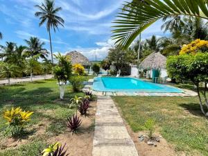 Monte GordoHotel Costa Belle的一个带游泳池和棕榈树的度假村