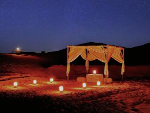 梅尔祖卡Luxury Merzouga Tents - Official的夜晚沙漠中带蜡烛的帐篷