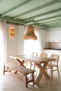 坎佩略Rooms by JovA的厨房配有木桌和椅子,配有吊灯