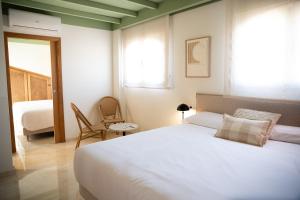 坎佩略Rooms by JovA的卧室设有一张白色大床和一扇窗户。