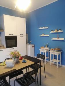 圣欧费米亚拉默齐亚Le Solite Holiday Rooms的厨房配有桌椅和蓝色的墙壁