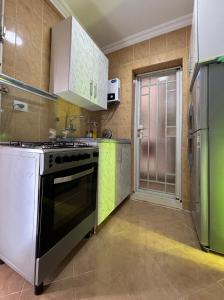 MadinatyLuxury Inn:2BR Amazing Garden View in Madinaty B10的厨房配有炉灶和冰箱。