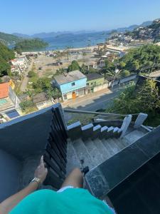 安格拉杜斯雷斯Casa Bela Vista的坐在阳台欣赏海洋景色的人