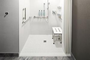 拉瓦尔Courtyard by Marriott Montreal Laval的带淋浴和盥洗盆的白色浴室