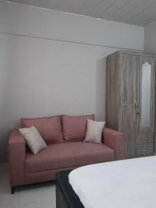 特马The Alpha residence的客厅配有棕色的沙发和镜子