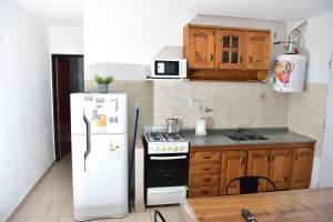 别德马Departamentos x dia Viedma 3 CON COCHERA的厨房配有白色冰箱和炉灶。