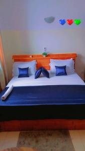 科托努Résidences Hôtel Perle Bleue的一张带蓝色和白色枕头的大床