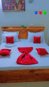 科托努Résidences Hôtel Perle Bleue的一张带红色枕头的床和红色的连衣裙