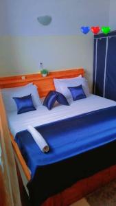 科托努Résidences Hôtel Perle Bleue的蓝色的白色床和蓝色的枕头
