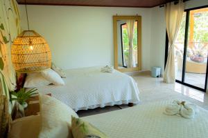 埃尔扎伊诺Ecohotel Yachay Tayrona的一间卧室配有两张白色的床和一盏灯
