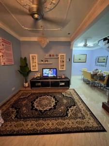 峇冬加里Iwan Ila Homestay的一间带电视和地毯的客厅