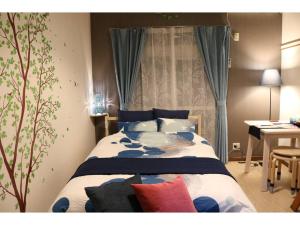 浦安Maison Cresta Urayasu - Vacation STAY 11150的一间卧室配有蓝色和白色的床