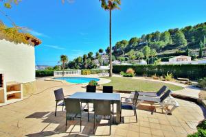 莫莱拉Alldo - hill side with private pool in Moraira的一个带桌椅的庭院和一个游泳池