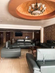 科隆Hotel Internacional de Colón的客厅配有皮革家具和吊灯。