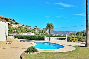 莫莱拉Alldo - hill side with private pool in Moraira的棕榈树和房子的院子内的游泳池
