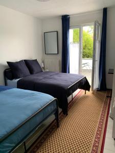 瑟农什Chambres Senonches centre-ville的一间卧室设有两张床和滑动玻璃门