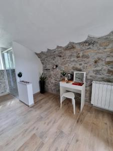 TresanaRosa di sera的一间设有白色书桌和石墙的客房