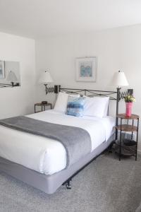 伊斯特海湾The Landmark Inn on Orcas Island的一张大白色的床,位于带两张桌子的房间
